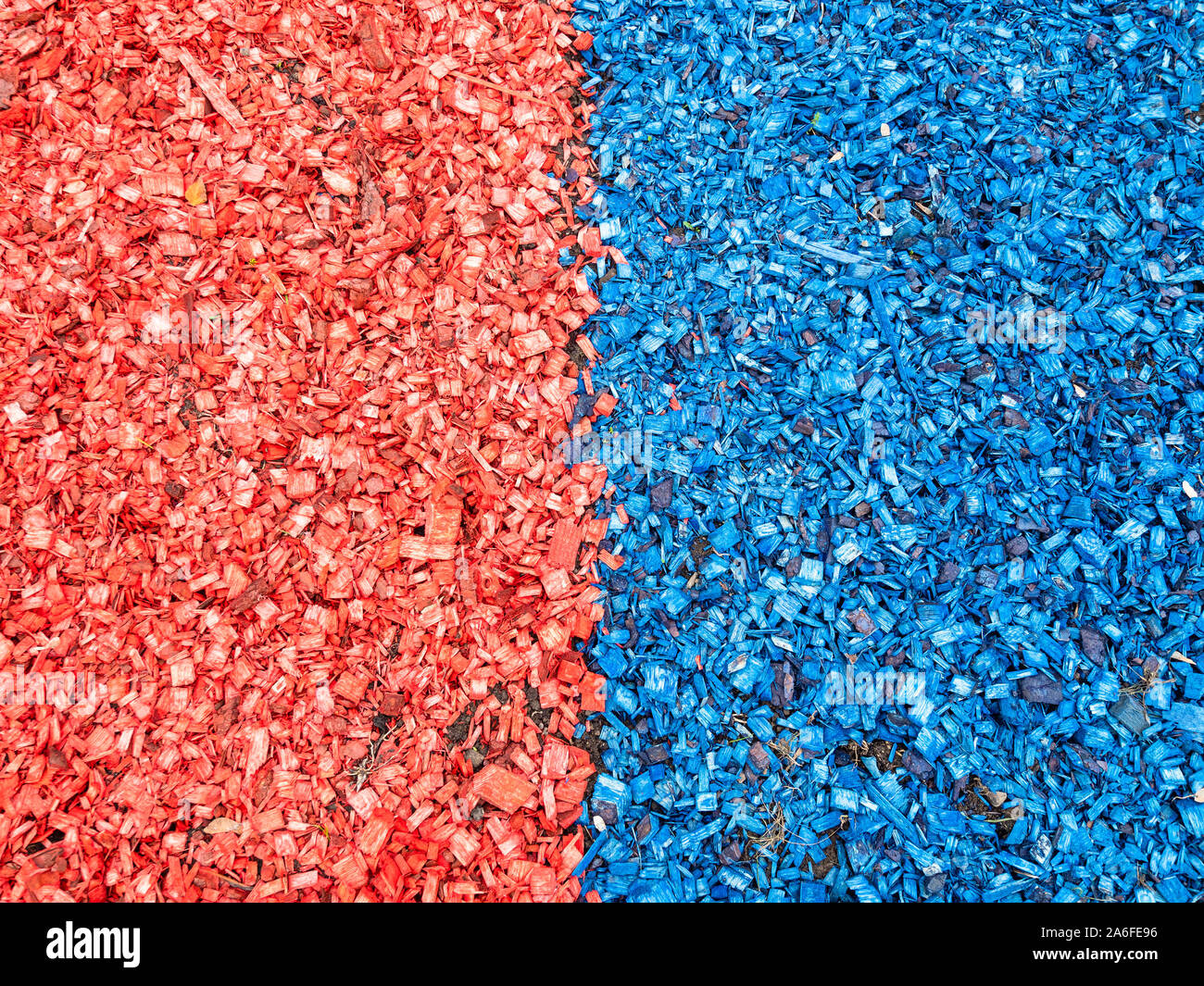 top view of red and blue colored wooden mulch on surface of soil on lawn Stock Photo