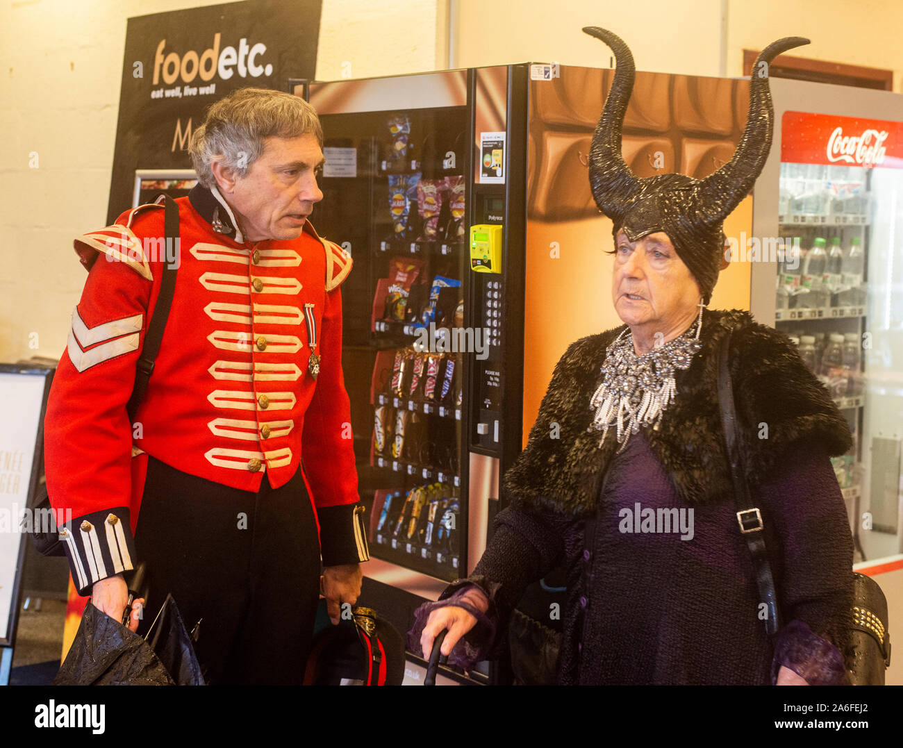 Senior couple in traditional Goth costumes by vending machines, Whitby Goth Weekend Festival, Whitby, North Yorkshire, UK, 26 October 2019 Stock Photo