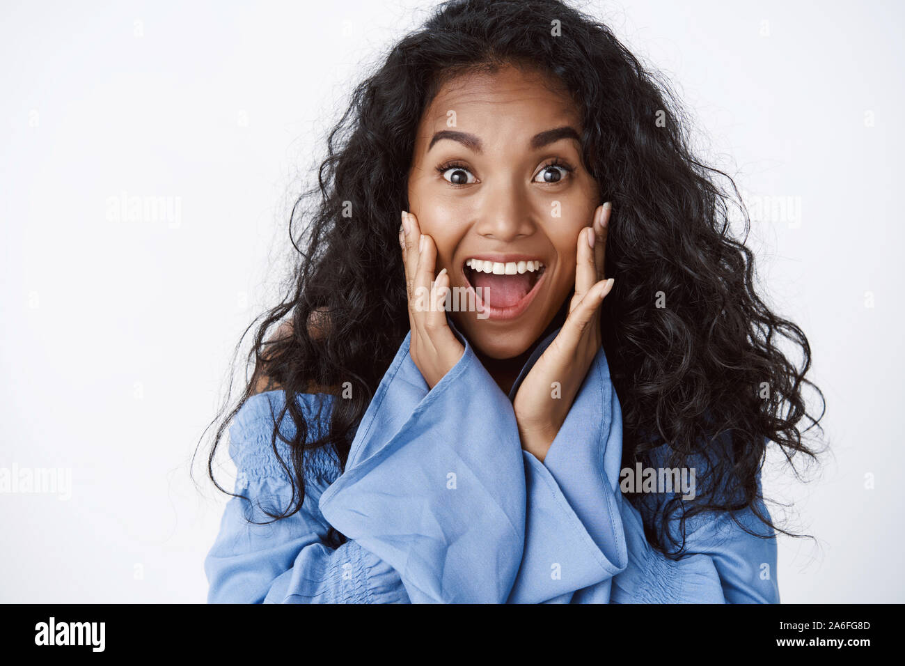 Surprised and glad enthusiastic africanamerican curlyhaired woman in stylish blue blouse open