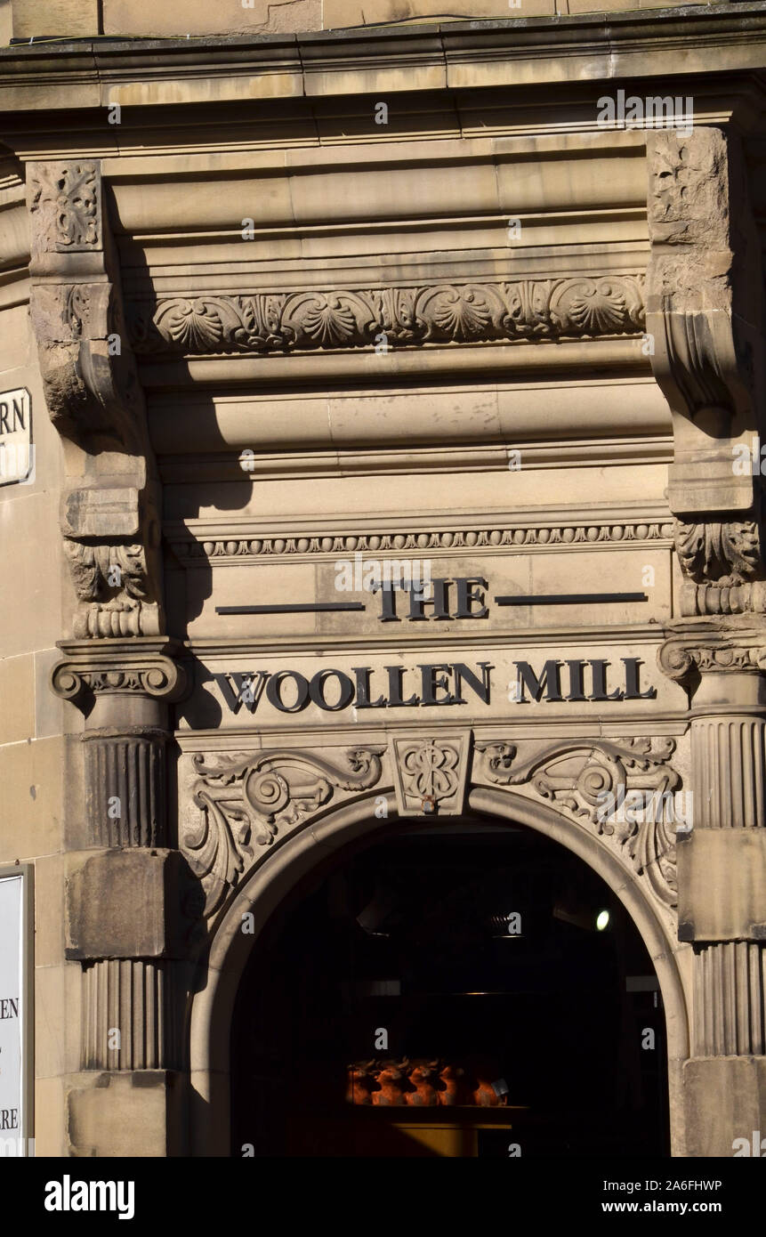 The beautiful stone facade of the building on the Royal Mile which houses The Woolen Mill shop Edinburgh Midlothian Scotland UK Stock Photo