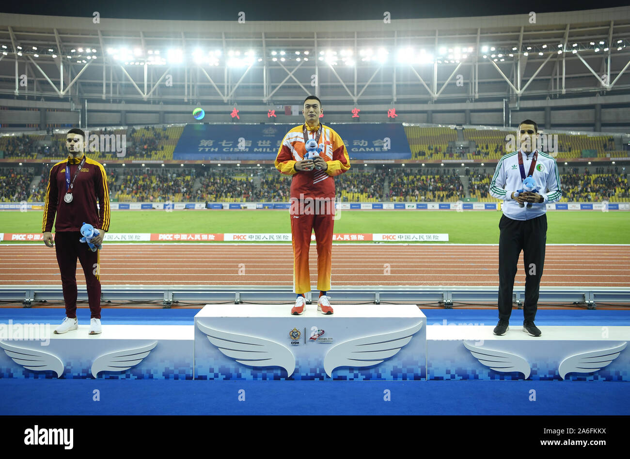 Wuhan, China's Hubei Province. 26th Oct, 2019.  Gold medalist Zhu Yaming (C) of China, silver medalist Tomas Veszelka (L) of Slovakia and bronze medalist Yasser M.T. Triki of Algeria attend the awarding ceremony of the men's triple jump final of track and field at the 7th CISM Military World Games in Wuhan, capital of central China's Hubei Province, Oct. 26, 2019. Credit: Fan Peishen/Xinhua/Alamy Live News Credit: Xinhua/Alamy Live News Stock Photo
