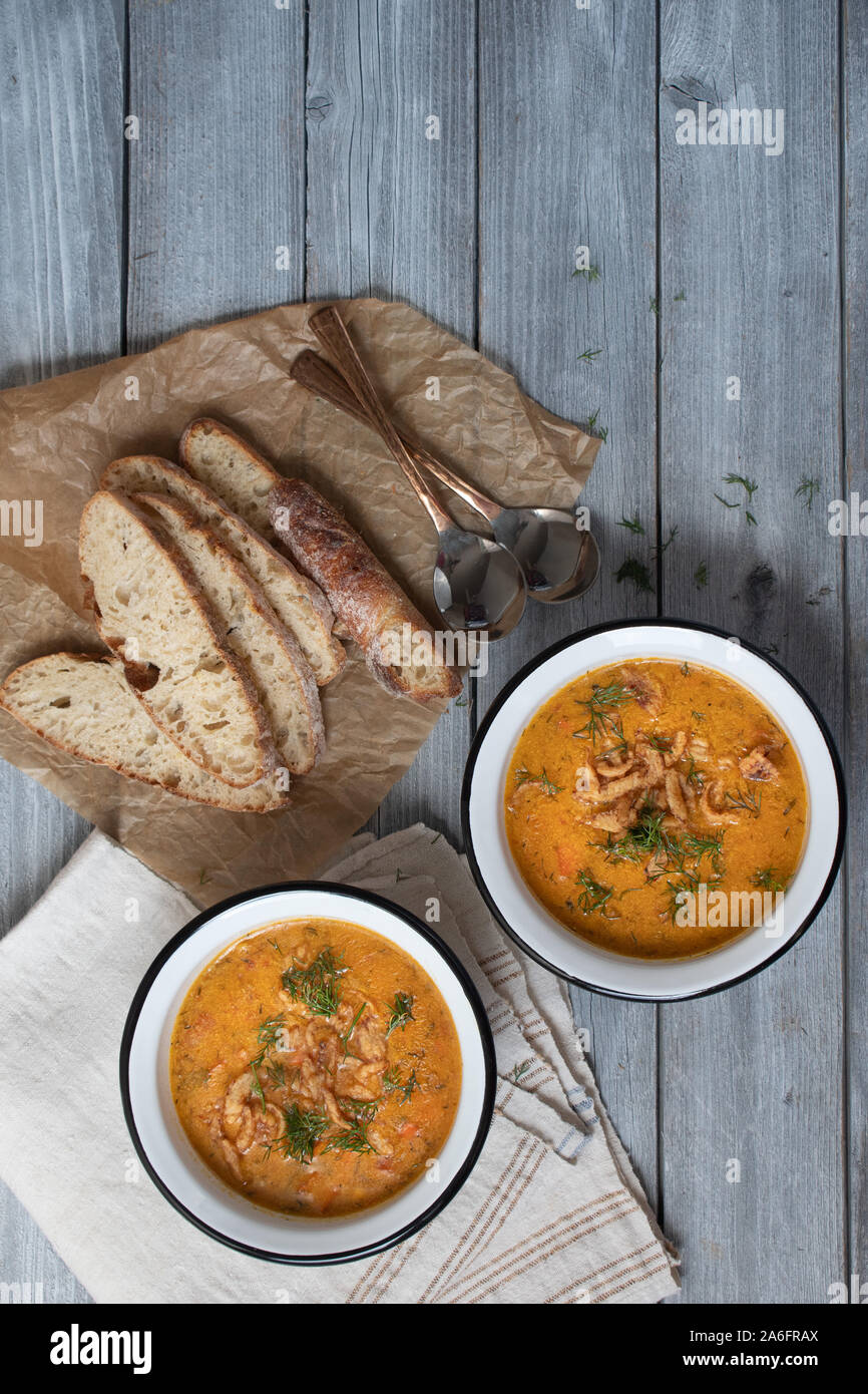 Vegan, gluten free corngrits soup with carrots and herbs, topped with crispy onions Stock Photo