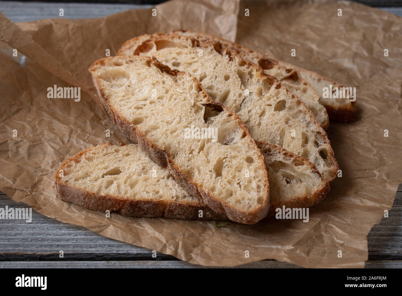 Ciabatta Bread slices on brown paper, wooden table Stock Photo - Alamy