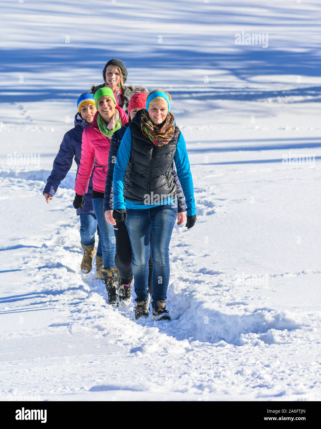 A group of young women doing a winterwalk at a sunny day in austrian alps Stock Photo