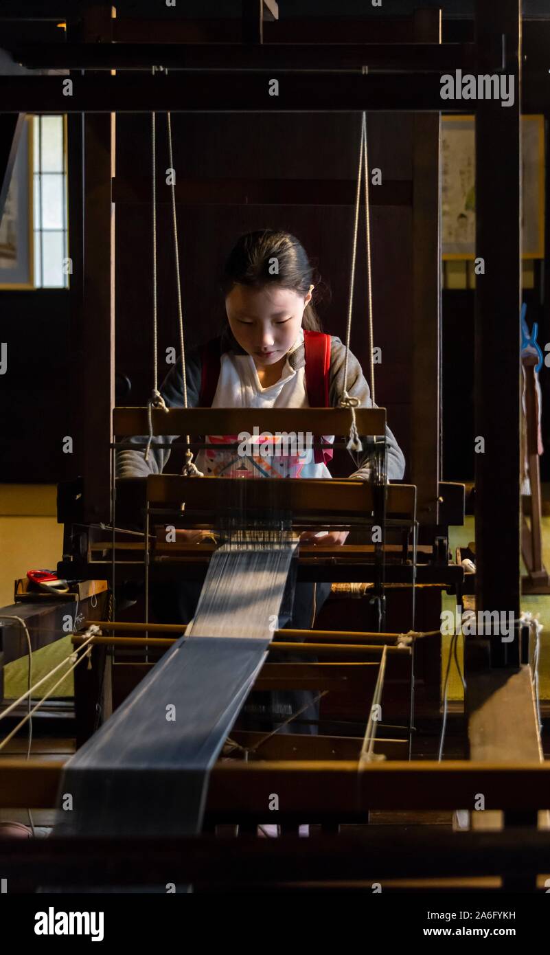 Japanese young woman weaving at the loom, Hida Minzoku Mura, Hida no Sato, Takayama, Japan Stock Photo