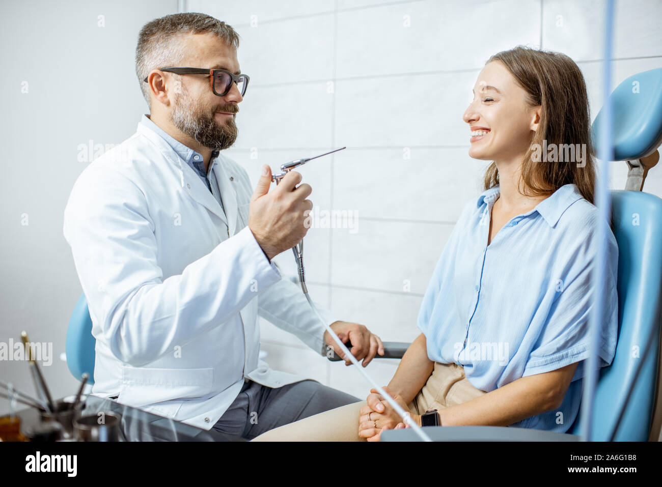 Senior otolaryngologist preparing for the oral flushing procedure for a young patient at the ENT