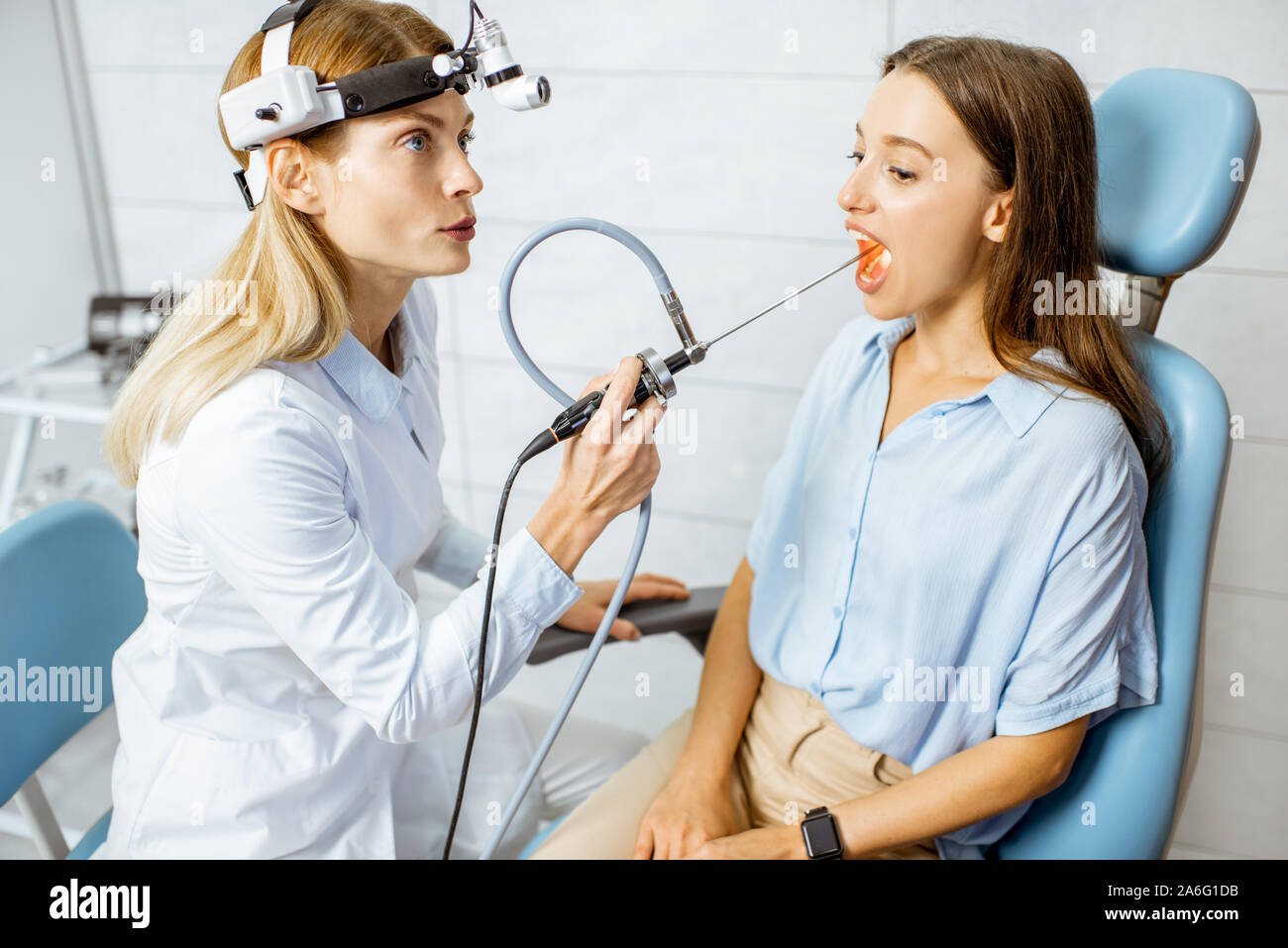 Senior otolaryngologist making endoscopic examination of an oral cavity