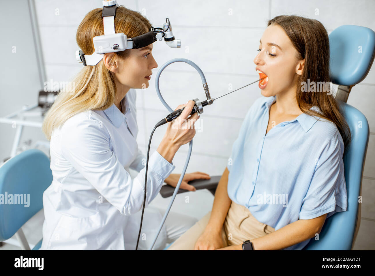 Senior otolaryngologist making endoscopic examination of an oral cavity