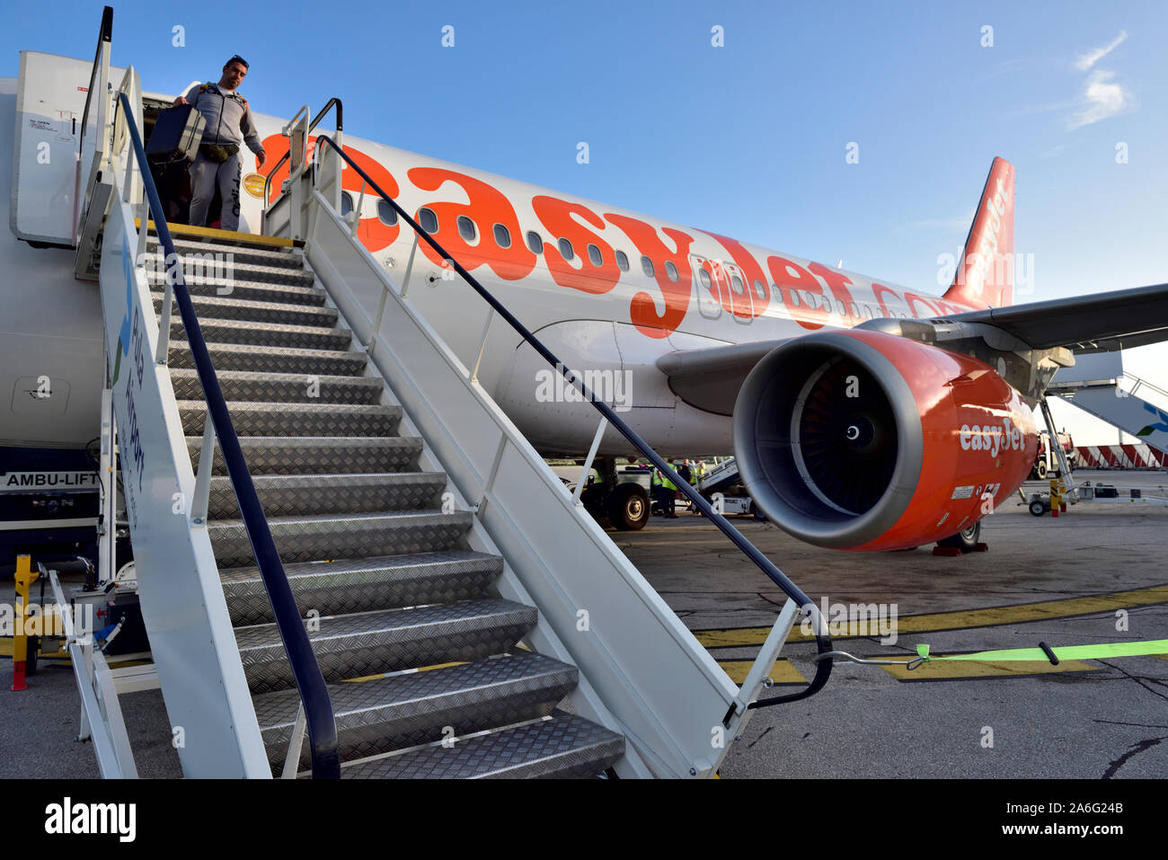 EasyJet plane with passenger at top of boarding, disembarking steps at front of plane Stock Photo