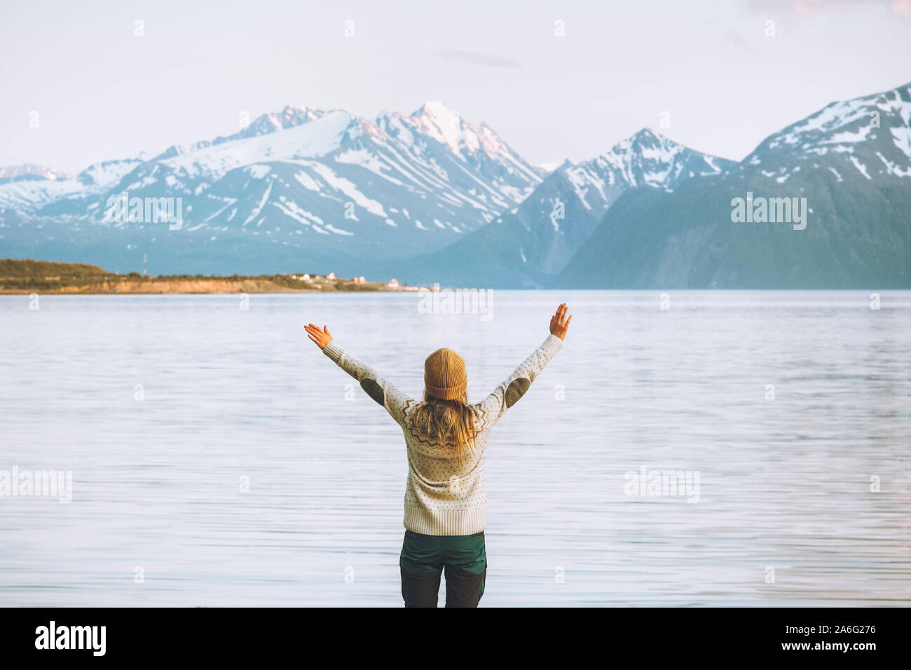 Traveler woman raised hands enjoying mountains view travel adventure vacations in Norway healthy lifestyle Lyngen Alps landscape Stock Photo