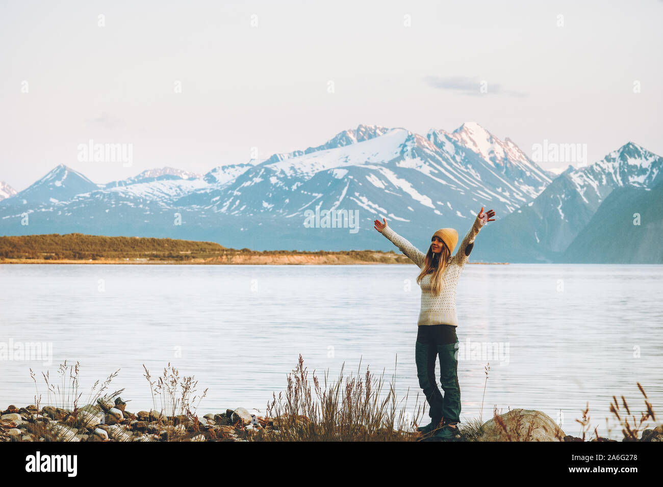 Woman adventurer raised hands enjoying mountains view travel adventure vacations in Norway harmony with nature Stock Photo
