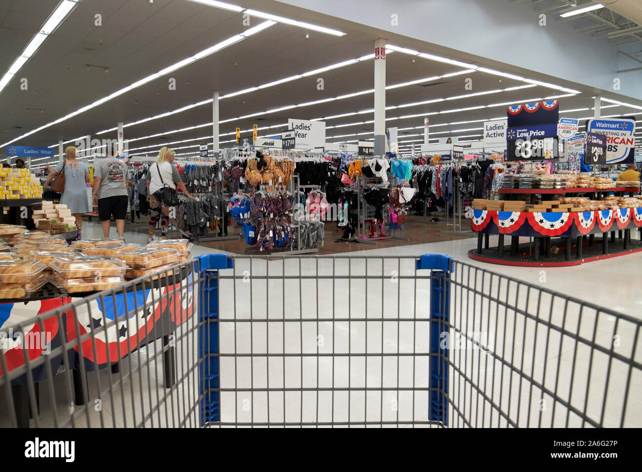 pushing trolley through walmart superstore bakery aisle and cheap clothes  indiana USA Stock Photo