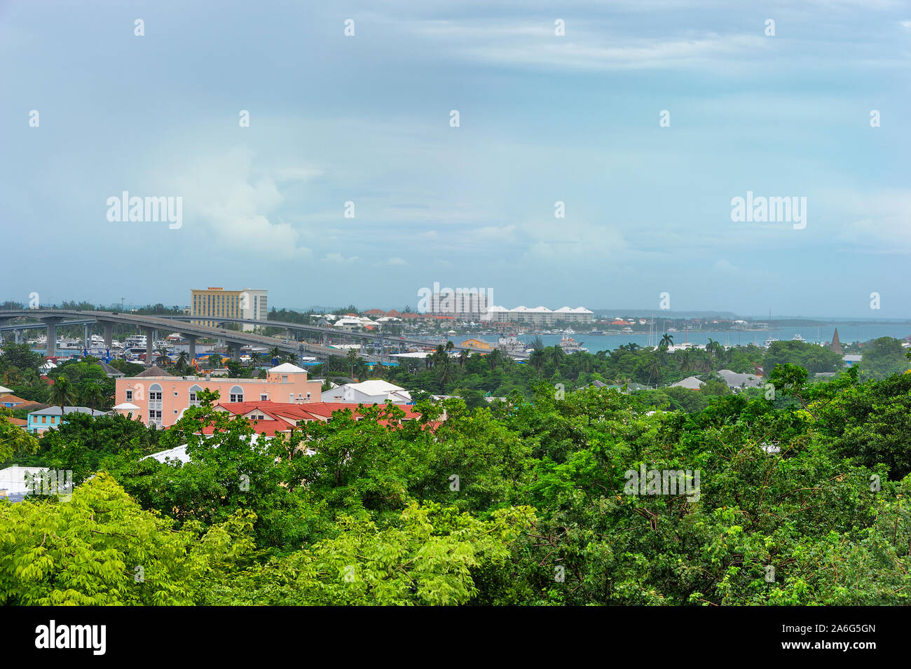 Vast views from on top of Bennetts Hill at Fort Fincastle, includes Paradise Island in the distance under stormy skies.  The rooftop of a yellow build Stock Photo