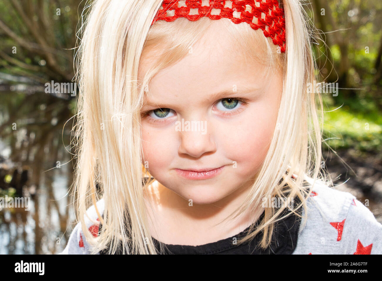 A Cute Blonde Haired Girl Wearing A Pretty Red Headband Laughing