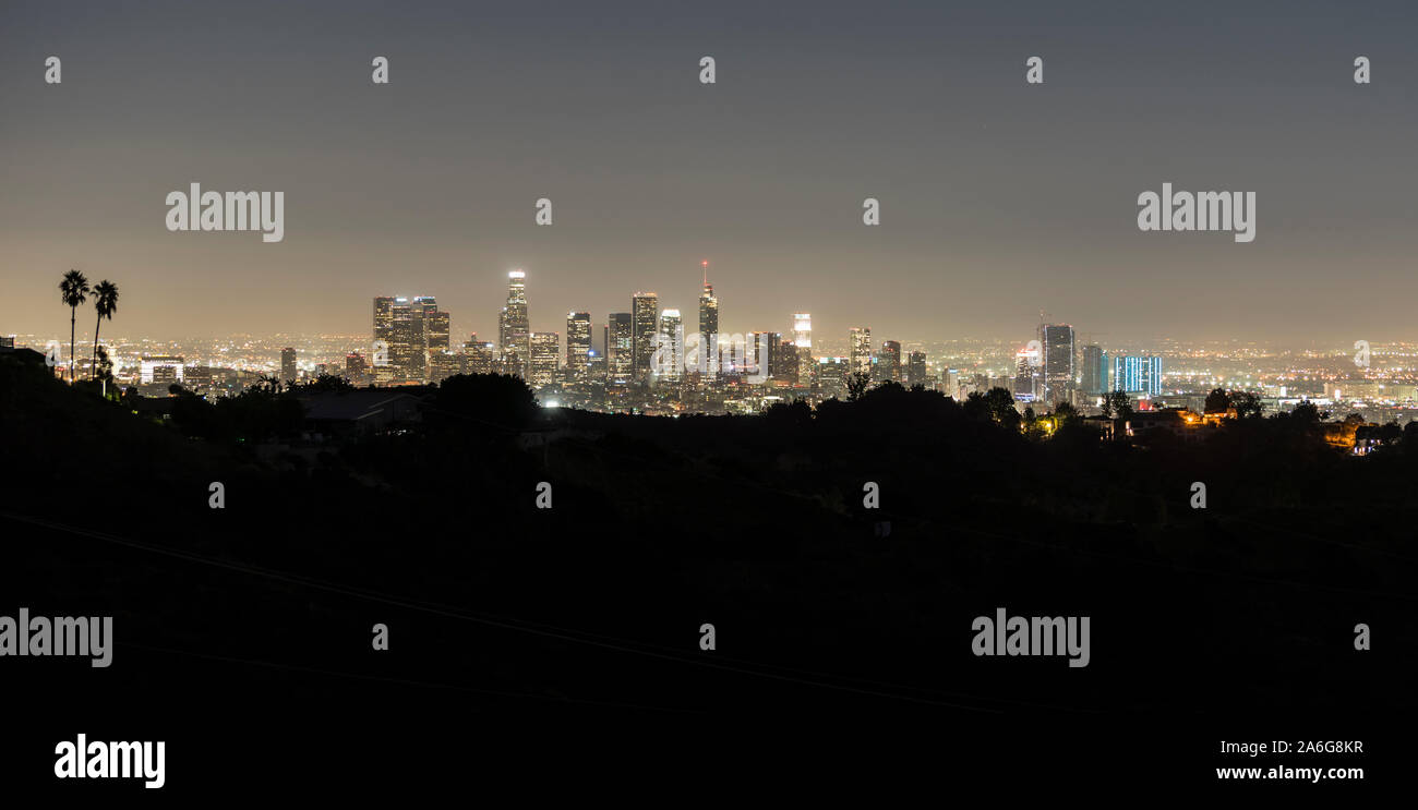 Night panorama view of downtown Los Angeles towers and hilltop ridge near popular Griffith Park in scenic Southern California. Stock Photo