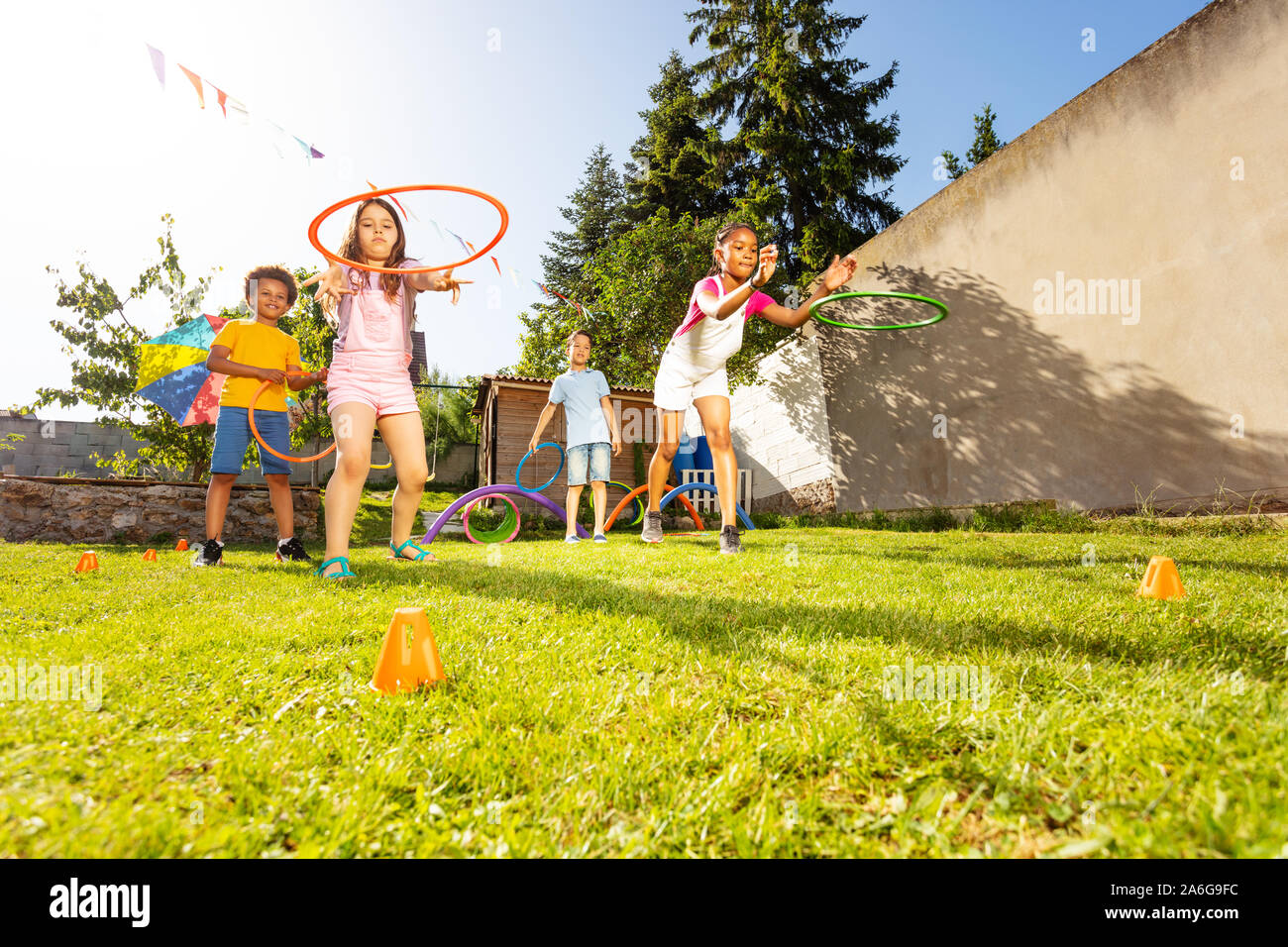 Group of kids throw hula rings to the target Stock Photo