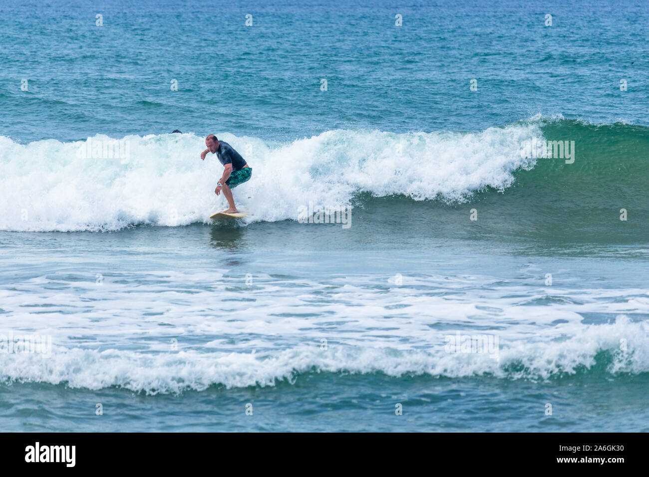 Hikkaduwa, Sri Lanka - 10/18/2019 - Pro surfer surfing at the Sri Lanka beach Stock Photo