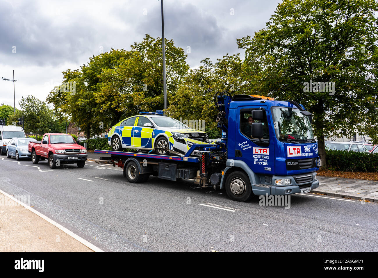 A crashed Police Car is towed on a tow truck in the city centre of