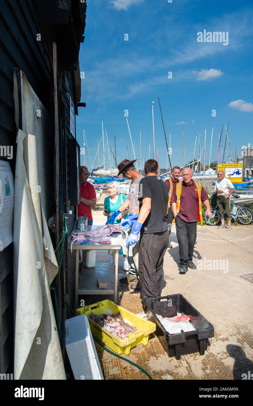 Fisherman prepare their catch of fresh fish ready for waiting customers Stock Photo