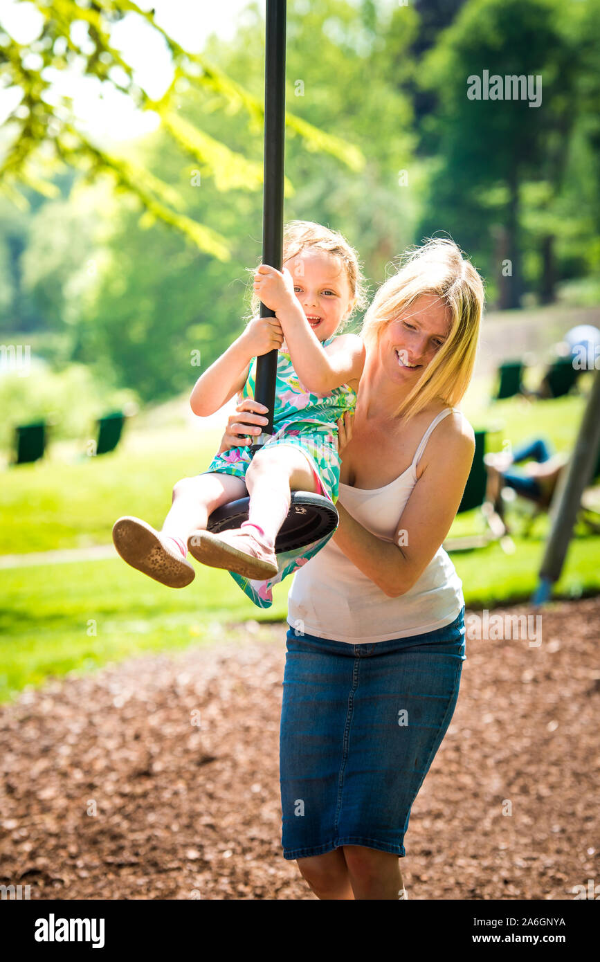 A pretty mother in her 40's cuddles playing with her daughter at the