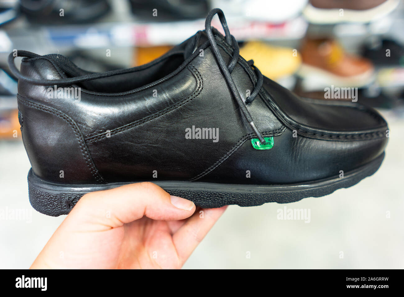 Boys and girls Kickers School shoes, footwear held by a man and on sale  before the new school year starts Stock Photo - Alamy