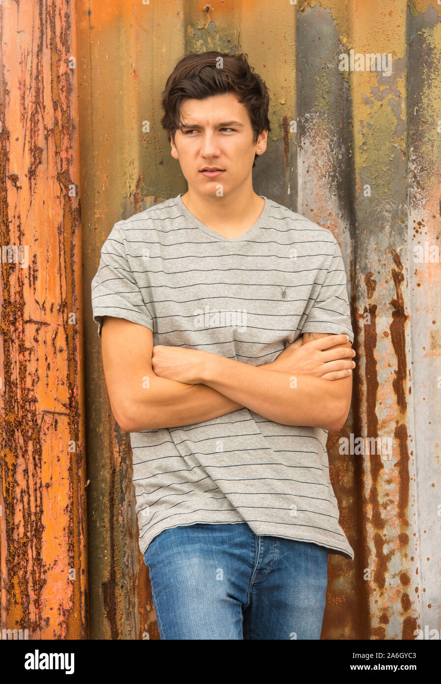 A young tall dark haired model poses for pictures in an old abandoned industrial compound Stock Photo