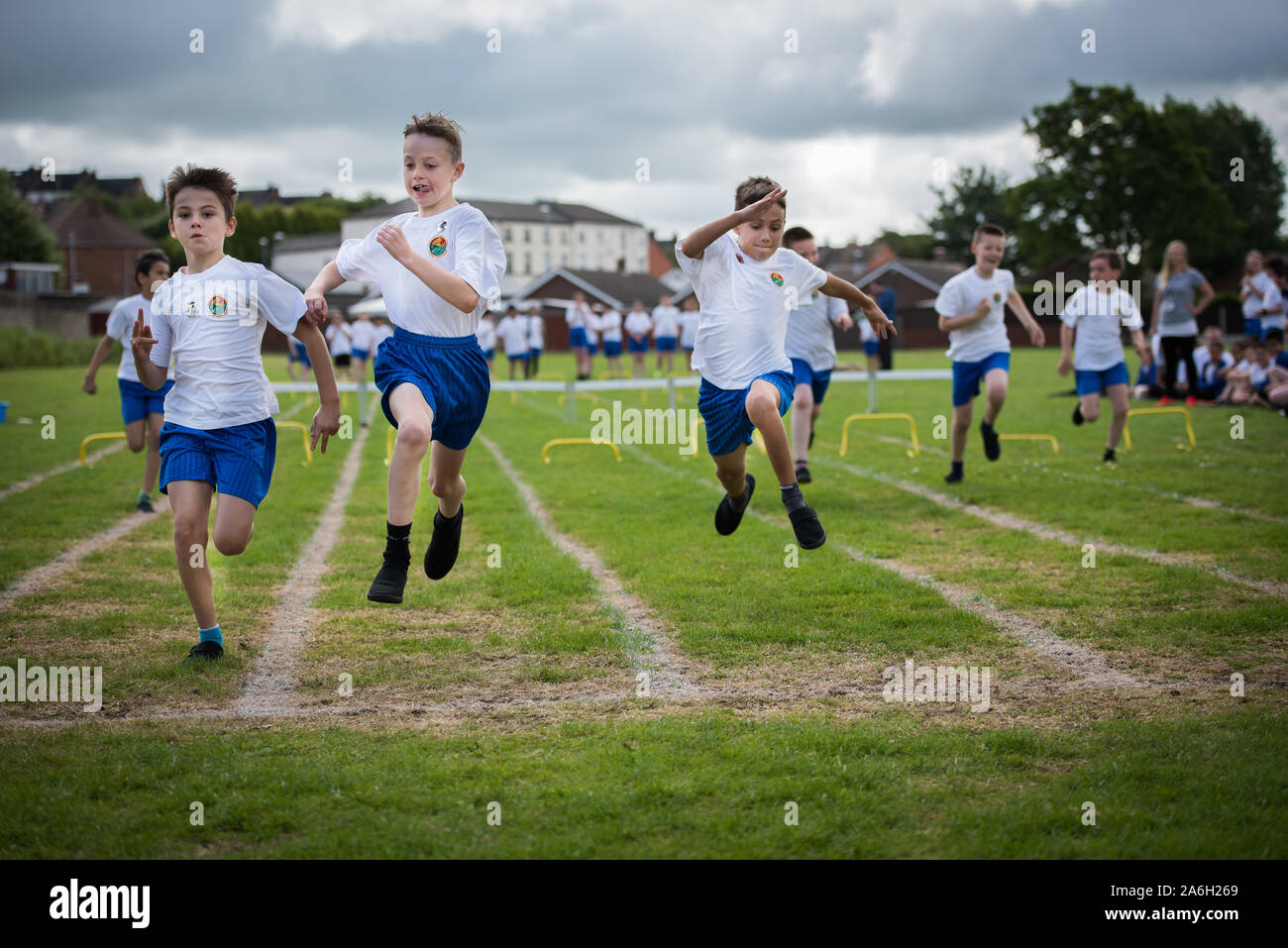 A young boy with ADHD, Autism, Asperger Syndrome takes part in a School sports day event, sitting preparing and sprinting in races, competition Stock Photo