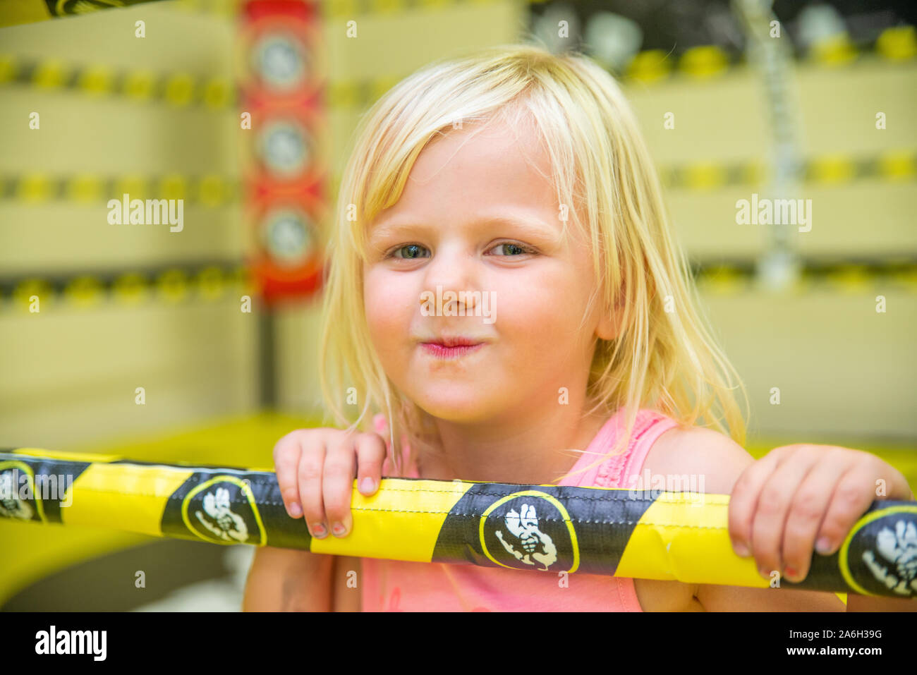A cute little girl in a boxing ring, mma ring, training with her