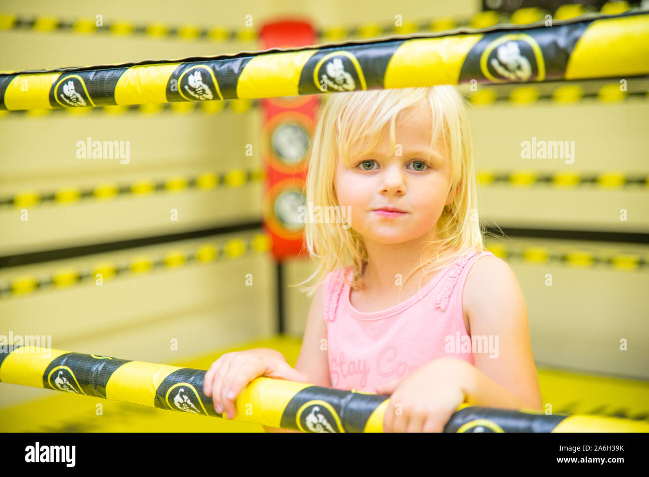 A cute little girl in a boxing ring, mma ring, training with her