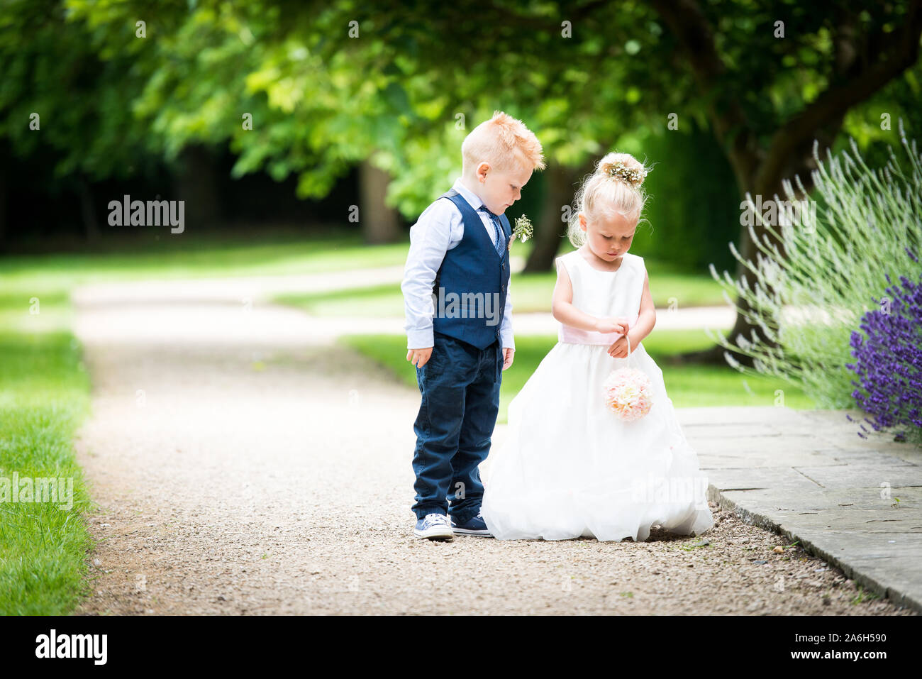 A little flower girl and page boy posing for cheeky pictures