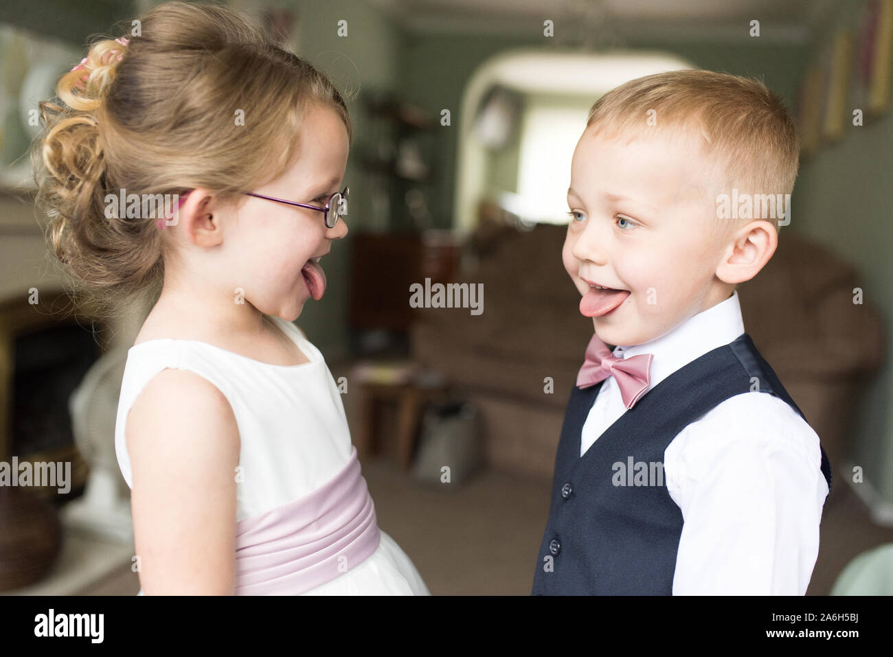 A little flower girl and page boy posing for cheeky pictures
