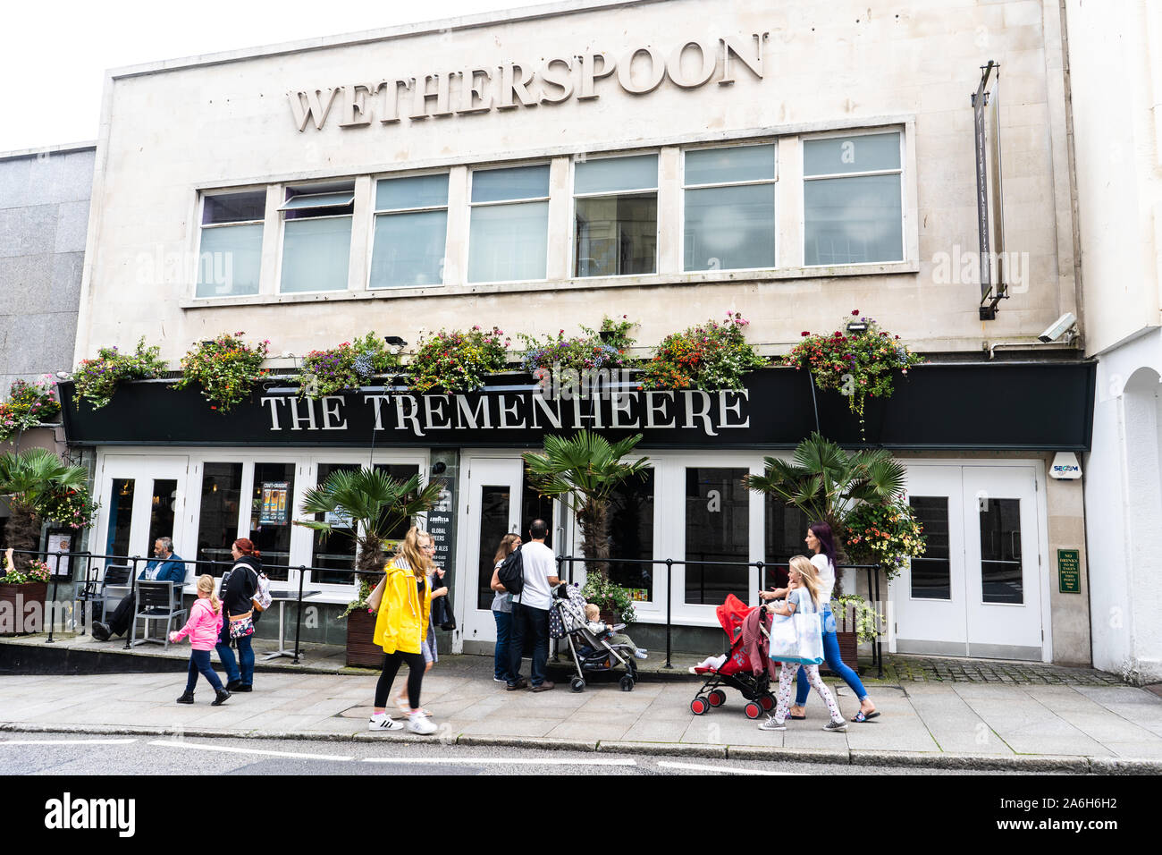 People walking by and entering the Tremenheere JD Wetherspoons pub in the highstreet of Penzance Stock Photo