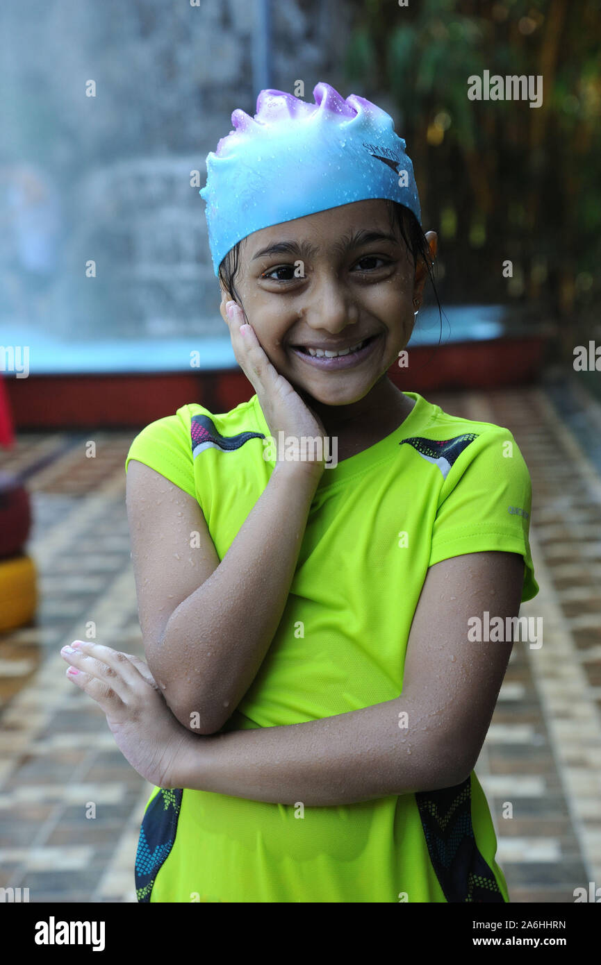outside portrait of water drops fall on little Indian girl in swimsuit