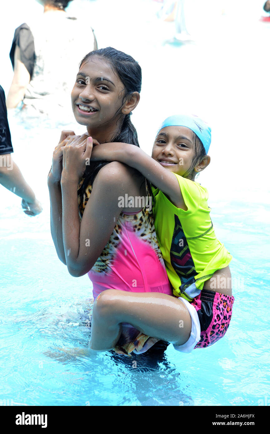 Indian two young girls taking bath having fun in swimming pool to get