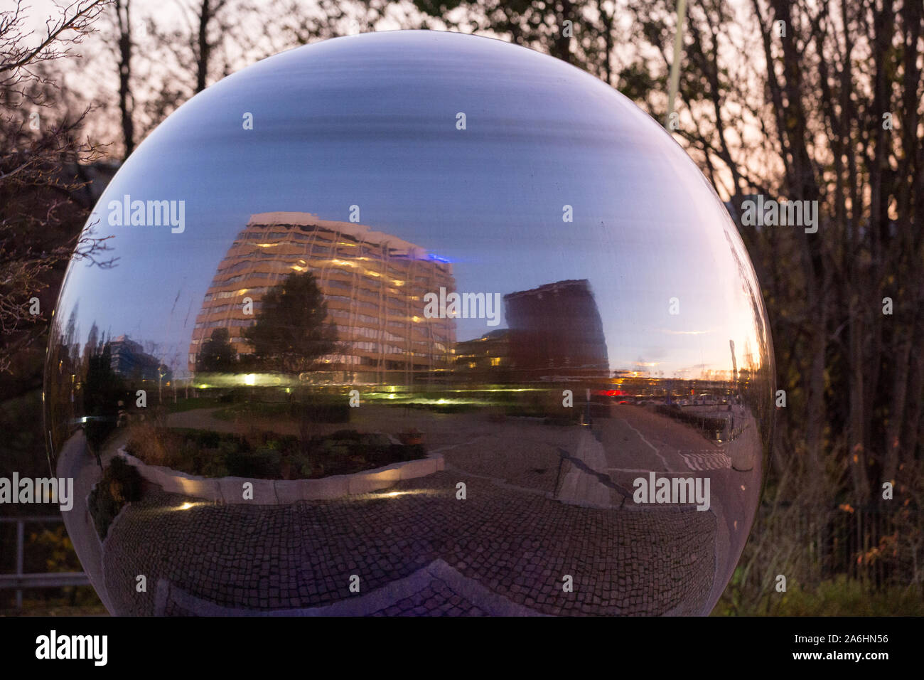 A large, reflective silver ball imitating a bearing in front of the SKF headquarter building.SKF
