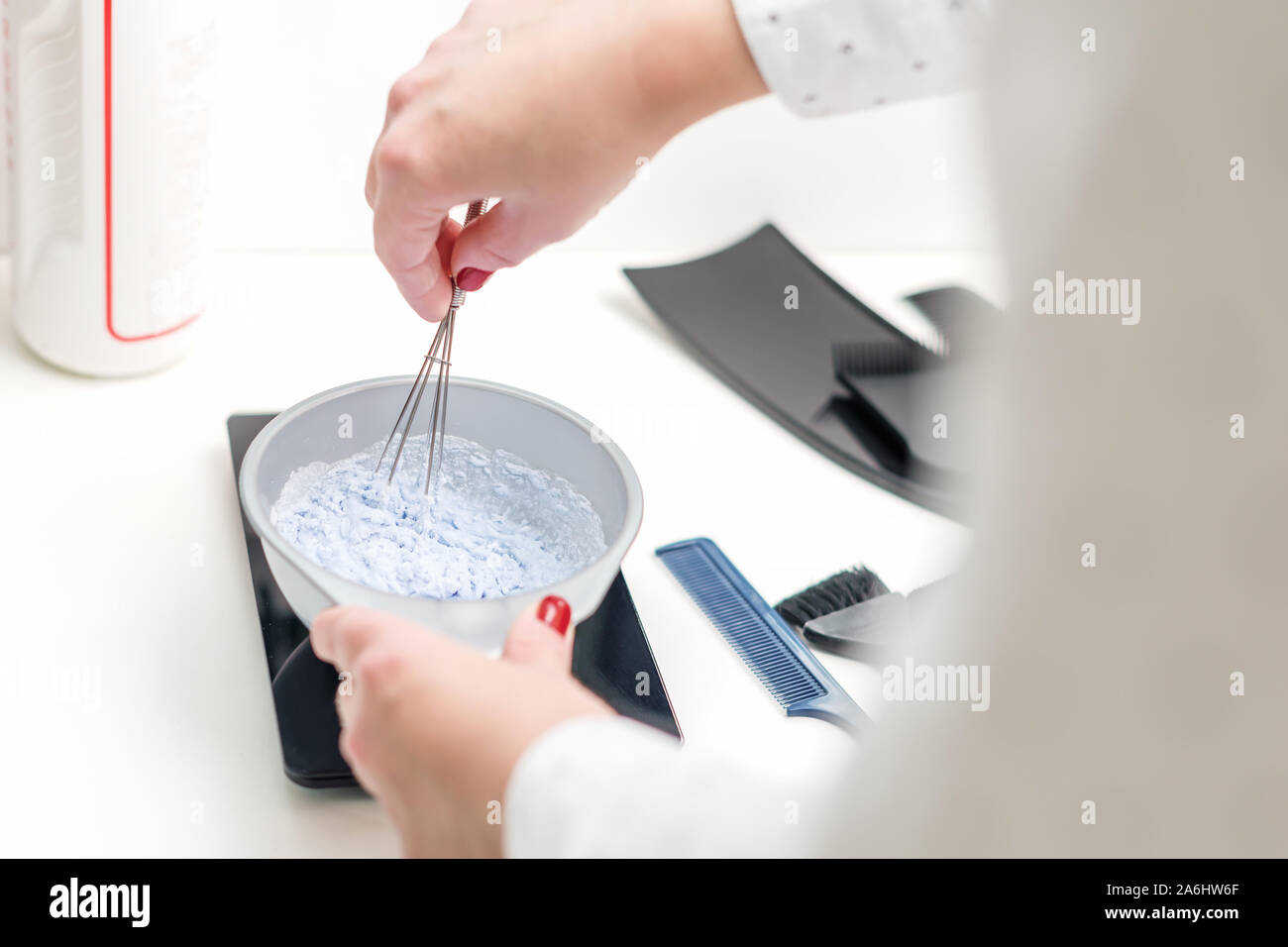 Hands of professional hairdresser are mixing hair dye in a bowl. Stylist  makes a white color mix for coloring hair at salon close up Stock Photo -  Alamy