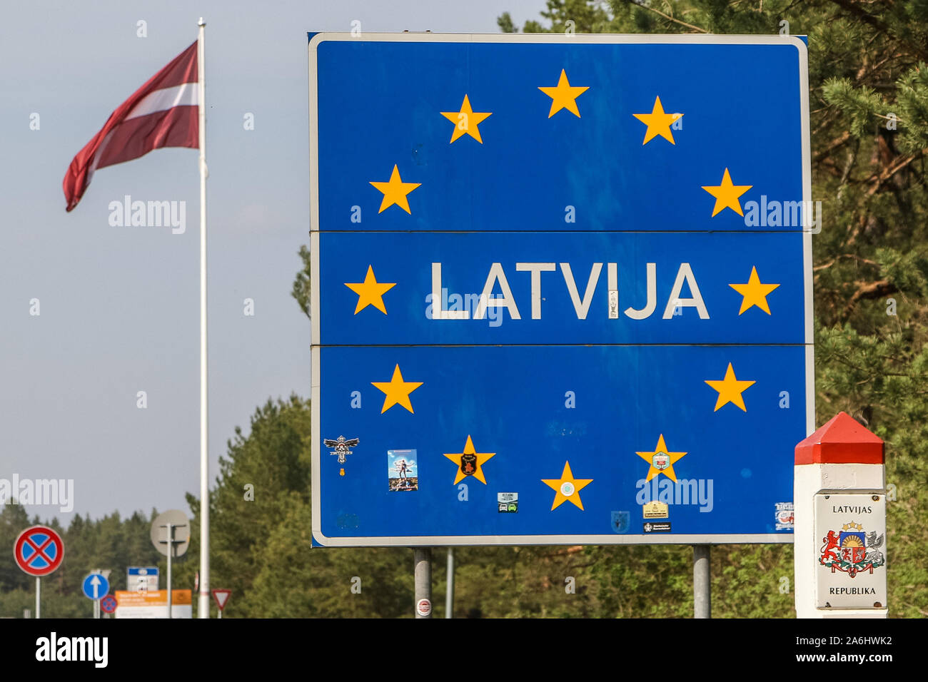 Latvia inscription on a sign with EU stars with with a Latvian flag in the  background is seen on a Lithuania - Latvia Schengen Area border crossing  Butinge (LT) - Rucava (LV)