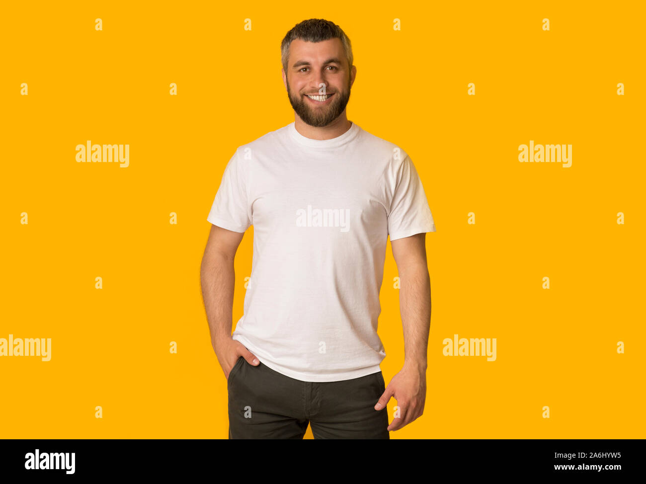 Positive bearded man posing over yellow background Stock Photo
