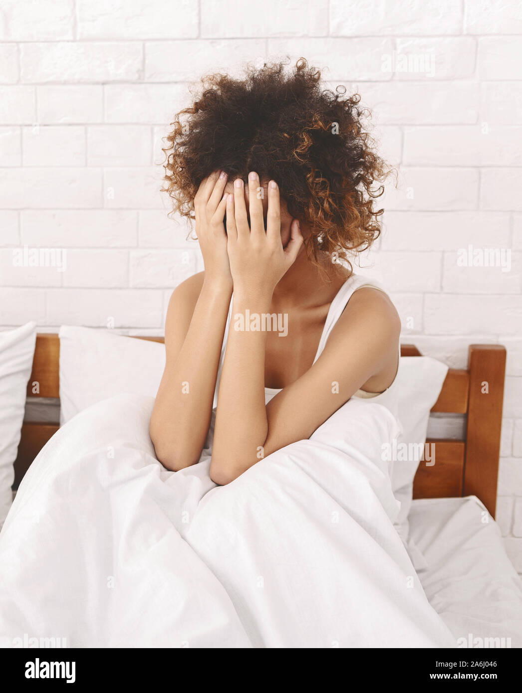 Sad young african american woman crying in bed alone Stock Photo