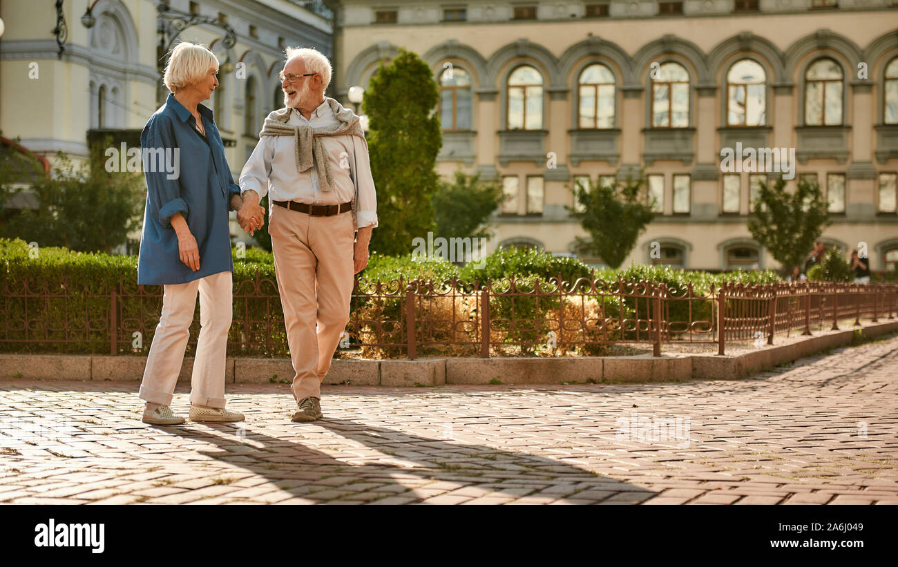 Romantic day. Beautiful and happy elderly couple holding hands and ...