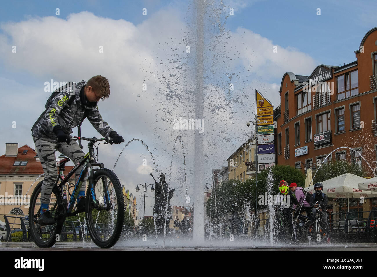 Children riding on bikes and scooters near the fountain in front of Casimir IV Jagiellon (Kazimierz Jagiellonczyk) monument are seen in the centre city of Malbork, Poland, on 18 May 2019  © Michal Fludra / Alamy Live News Stock Photo