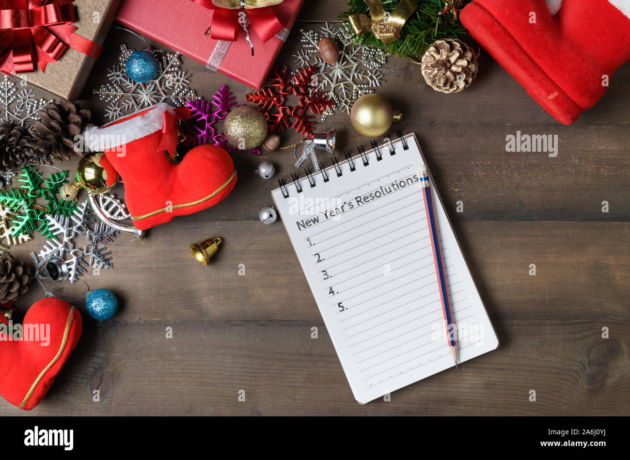 New year resolutions text on note paper with decorations and gift boxes