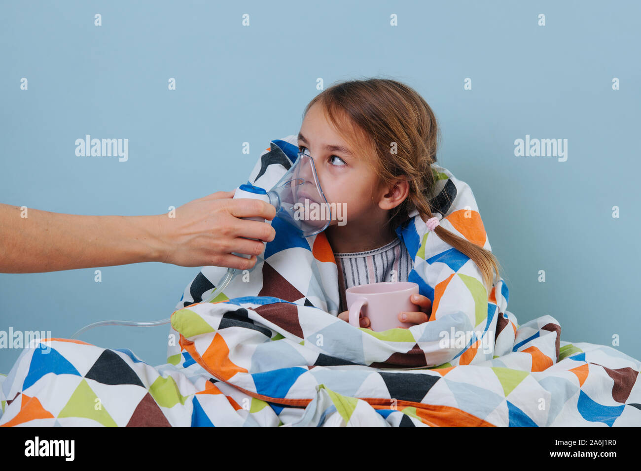 Sick girl with common cold sitting in bed under blanket with steam inhaler Stock Photo Alamy
