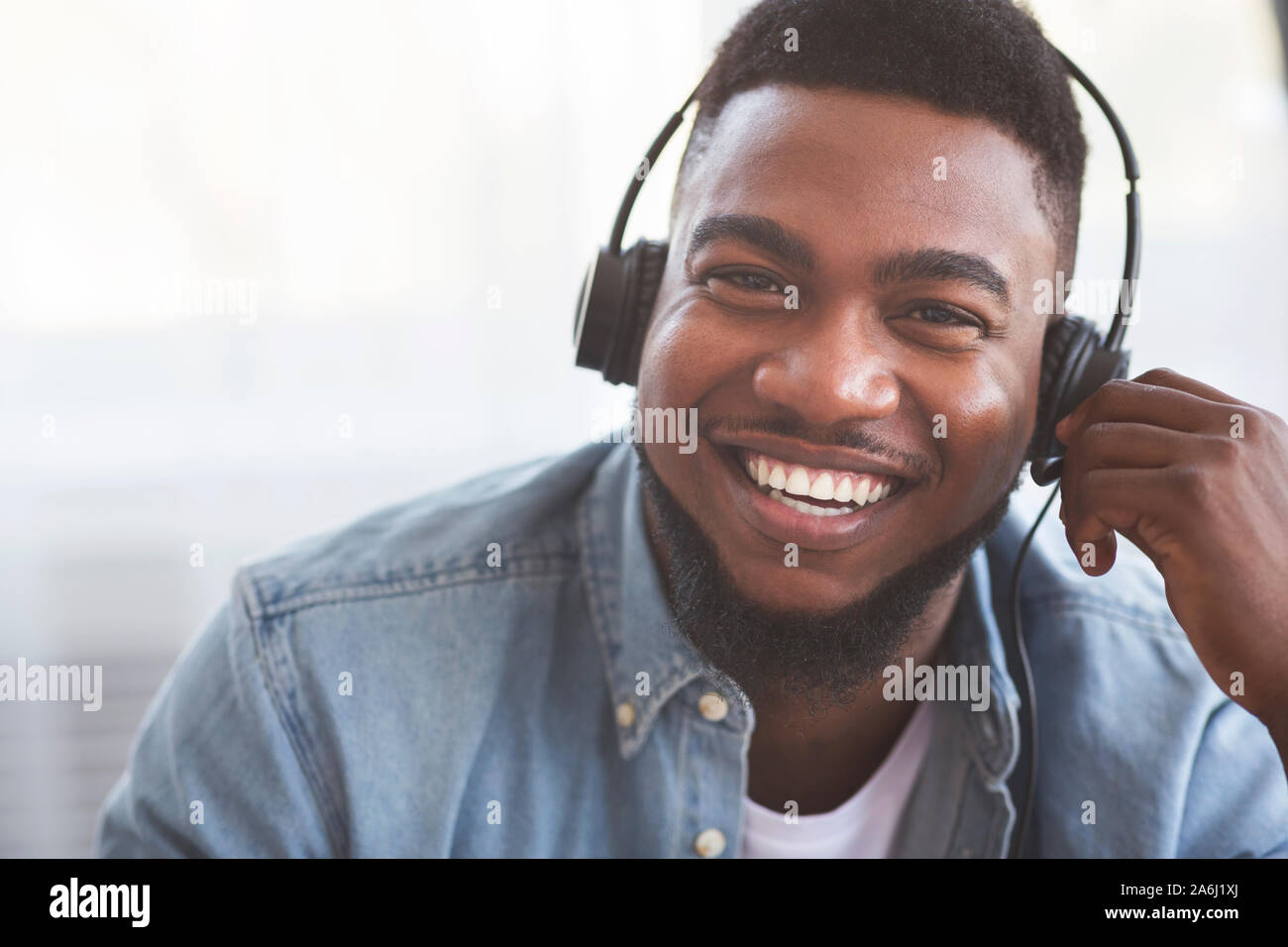 Portrait of smiling black call center operator in headset Stock Photo