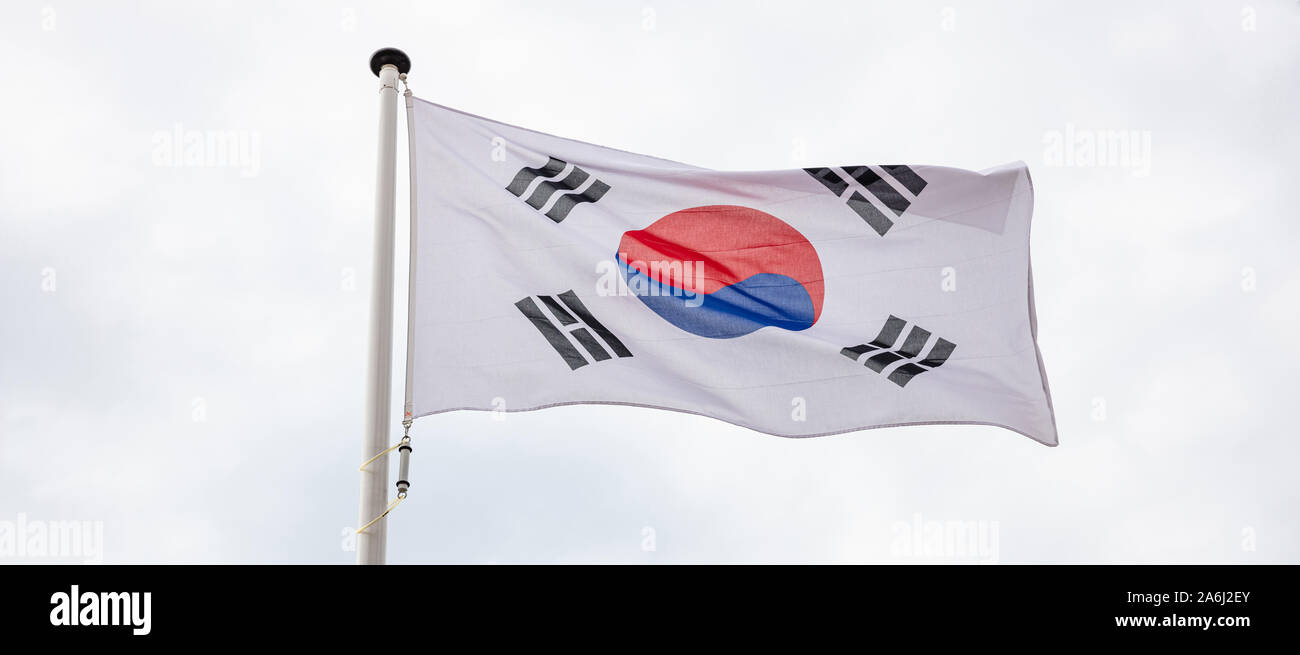 South Korea flag. South Korean national sign and symbol waving on a flagpole against cloudy sky background Stock Photo