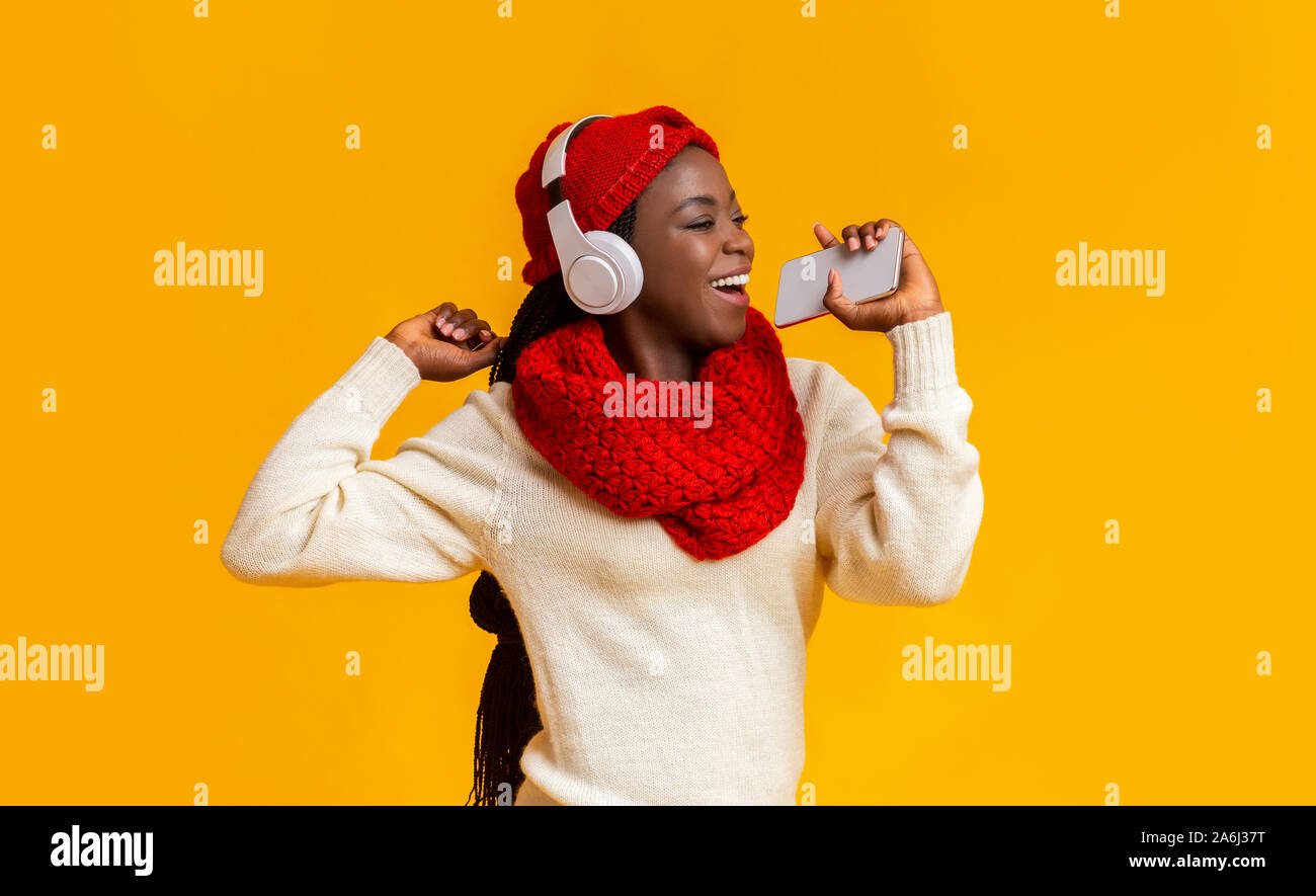 Joyful black girl in headphones listening to music and singing Stock ...