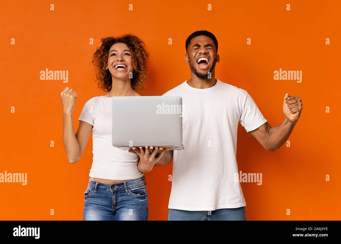 Emotional african couple with laptop enjoying win Stock Photo - Alamy
