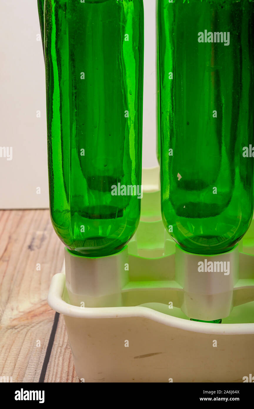 Empty wine bottles in a plastic dryer on the table Stock Photo