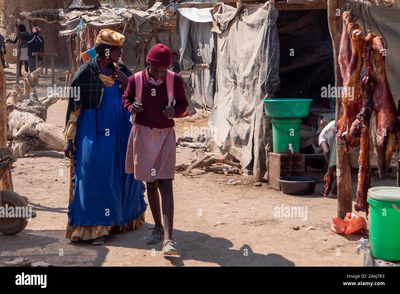Opuwo, Namibia - July 25 2019: Old Woman in Traditional Herero Clothing and Young Schoolgirl in School Uniform on the local Market in Opuwo between Po Stock Photo