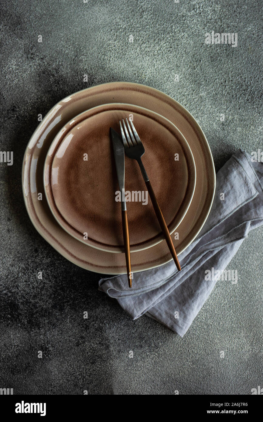 Cutlery set with empty plates on stone background with copy space Stock Photo